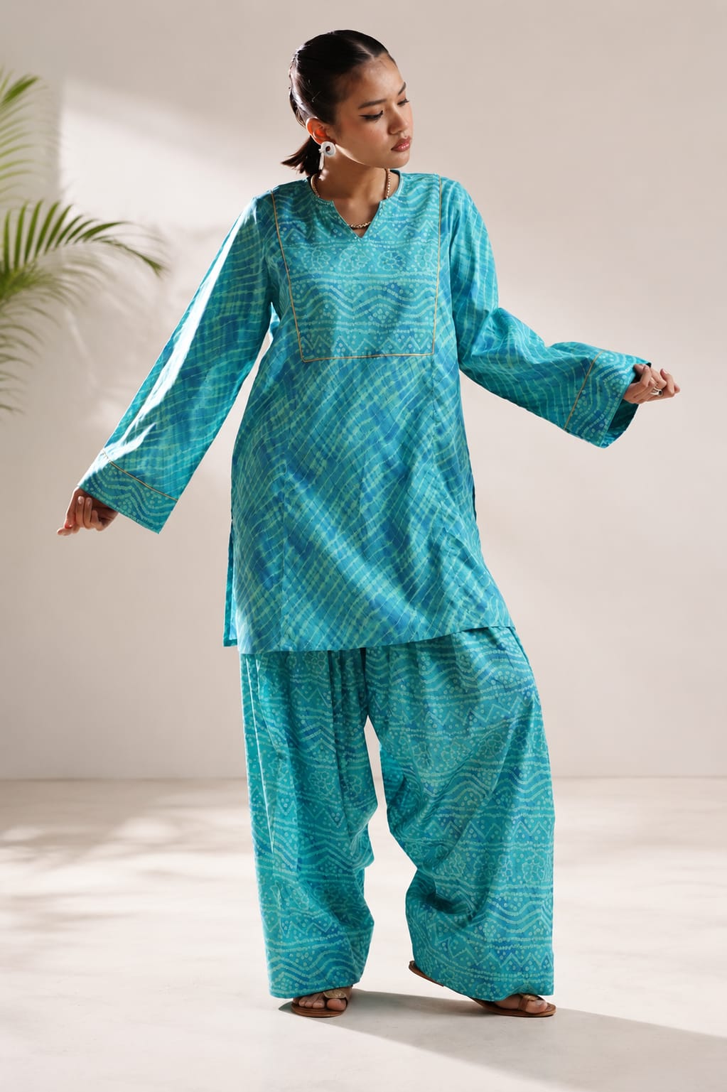 Teal bandhani print kurta set with V-neck, bell sleeves and farshi shalwar for women in Pakistan